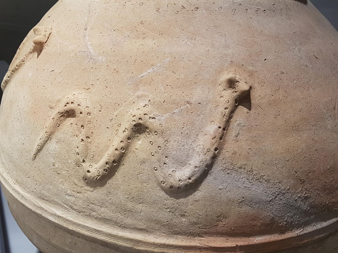 Serpent relief on a ceramic vessel from Saruq Al-Hadid on museum display